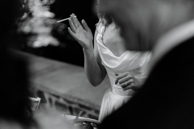 A bride at a candlelit reception, laughing, in black and white