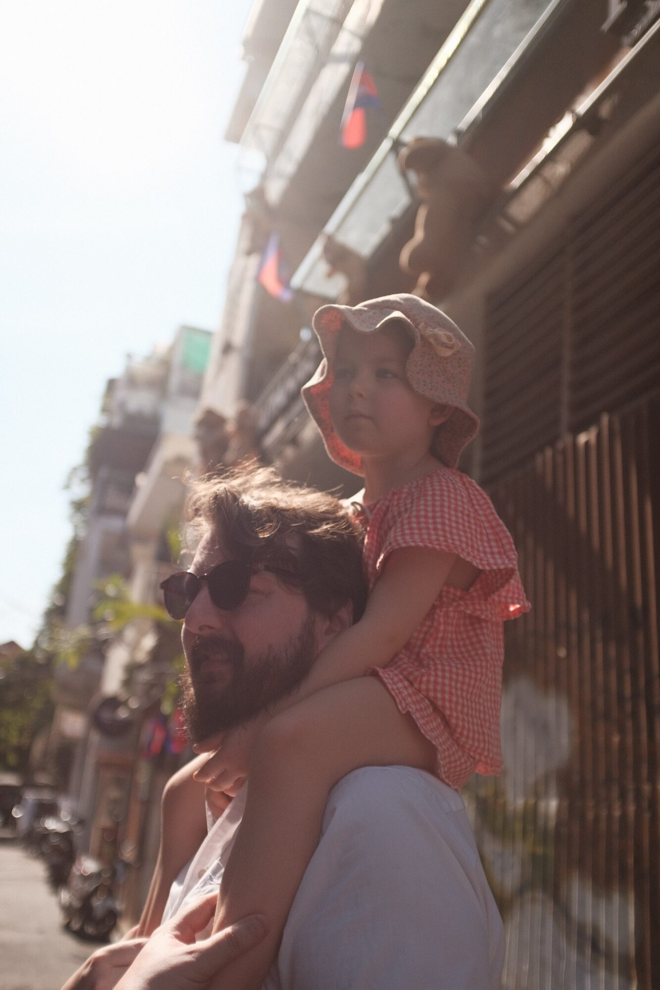 Tanner carrying his daughter Frankie on his shoulders down a sunlit street